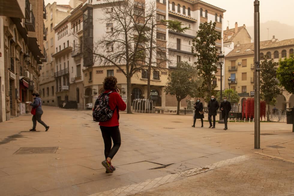 Gente paseando en Jaén, recubierto de polvo por la calima