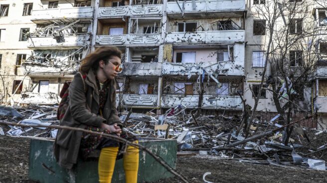 Una mujer, junto a un edificio bombardeado en Kiev.