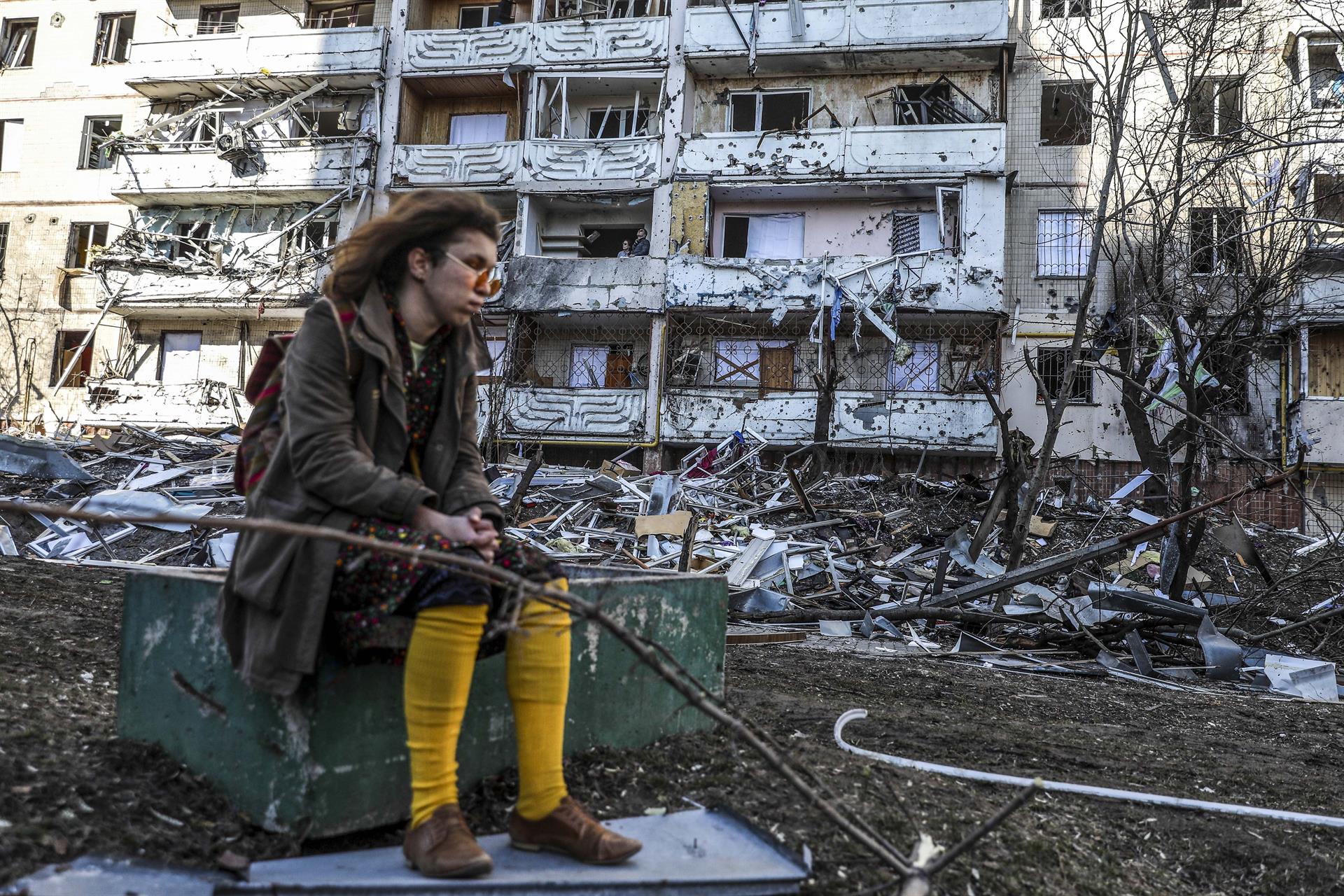 Una mujer, junto a un edificio bombardeado en Kiev.