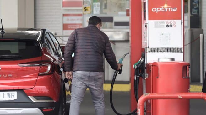 Una persona reposta combustible, en un coche, en una gasolinera de CEPSA