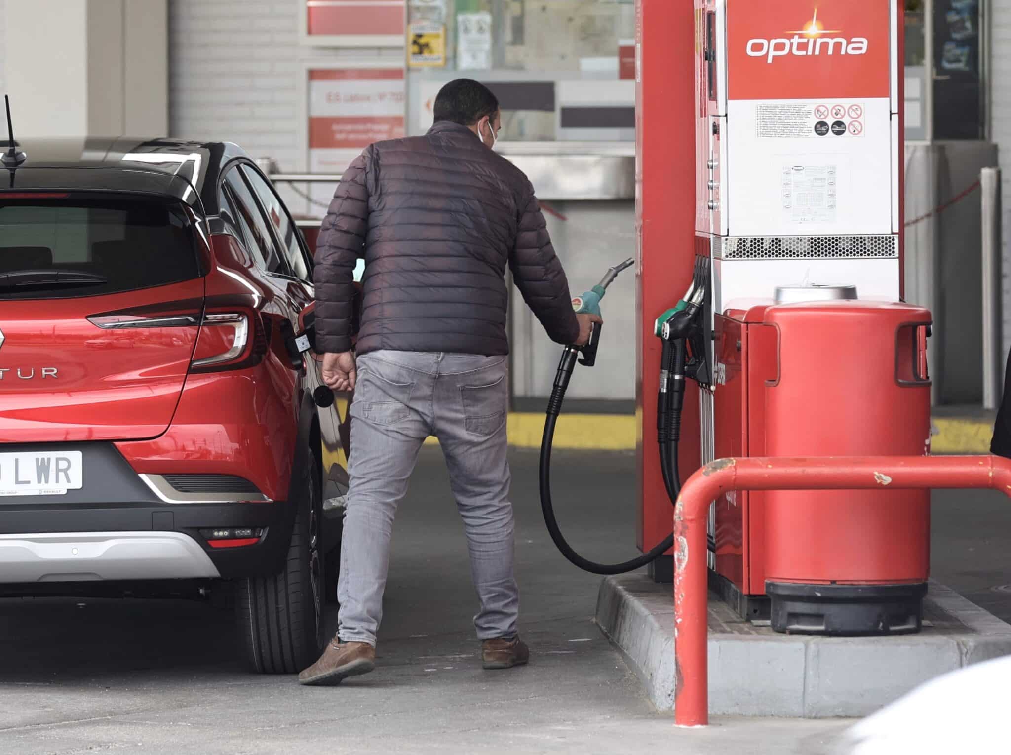Una persona reposta combustible, en un coche, en una gasolinera de CEPSA