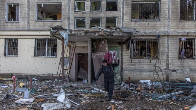 Un hombre sale con su maleta del edificio bombardeado ayer en Kiev