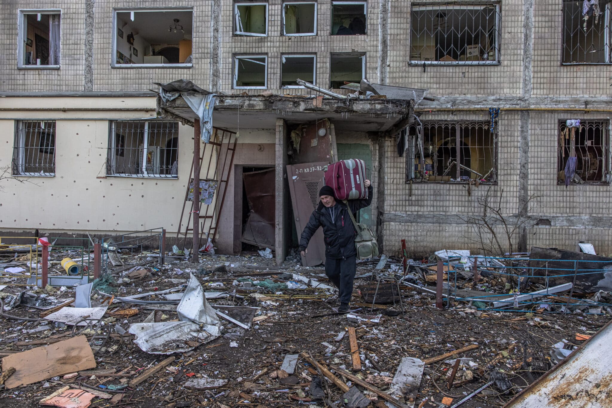 Un hombre sale con su maleta del edificio bombardeado ayer en Kiev