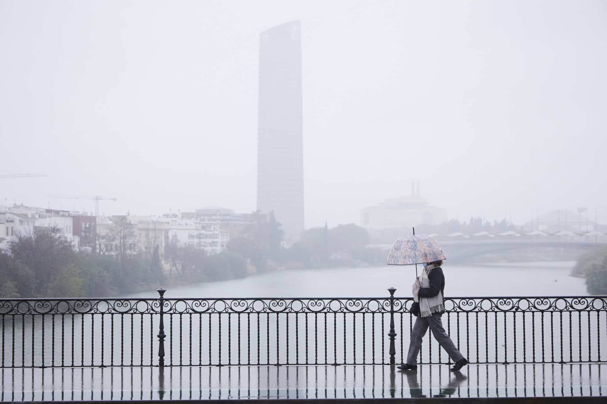 Una mujer pasea por Sevilla con paraguas