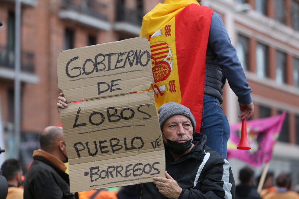 Un manifestante sostiene una pancarta que reza 'Gobierno de lobos, pueblo de borregos', en la marcha ‘20M’