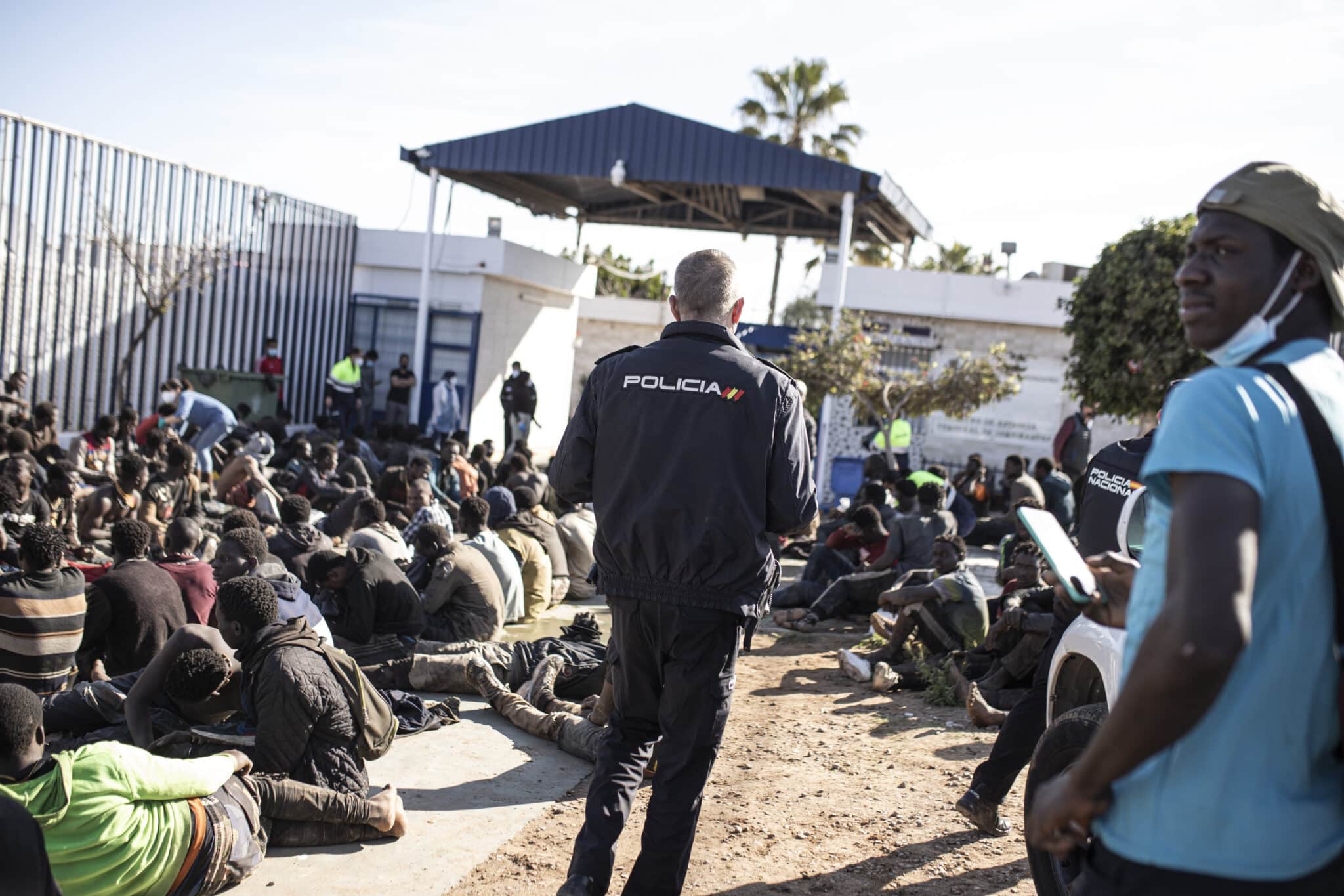 Un policía nacional y varios migrantes en el CETI de Melilla