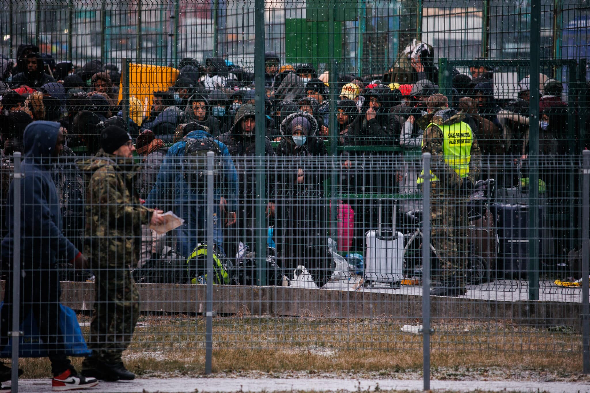 Ucranianos esperan detrás de una verja para entrar a Polonia, en el paso fronterizo de Medyka.
