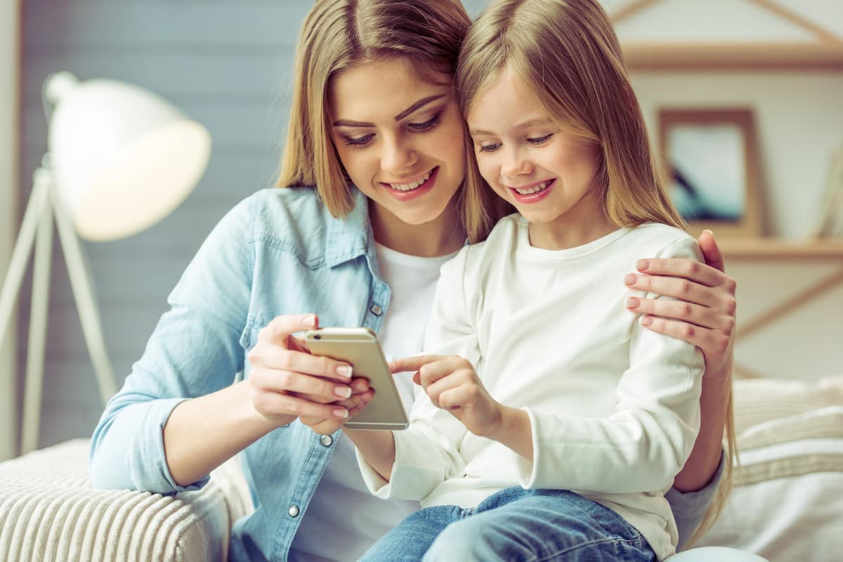 Madre e hija viendo un teléfono móvil