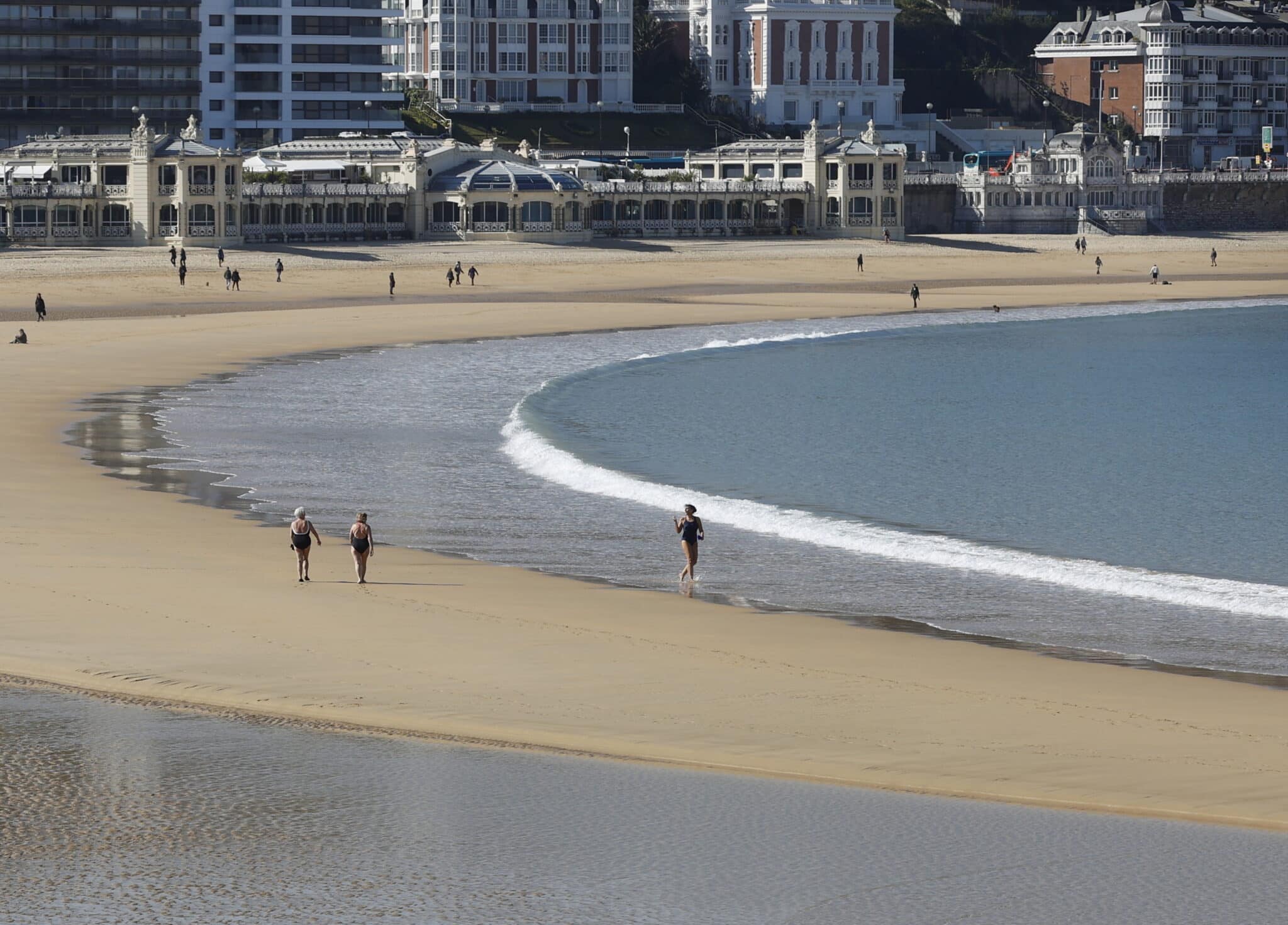 Varias personas pasean este martes (abril 2022) por la playa de La Concha de San Sebastián