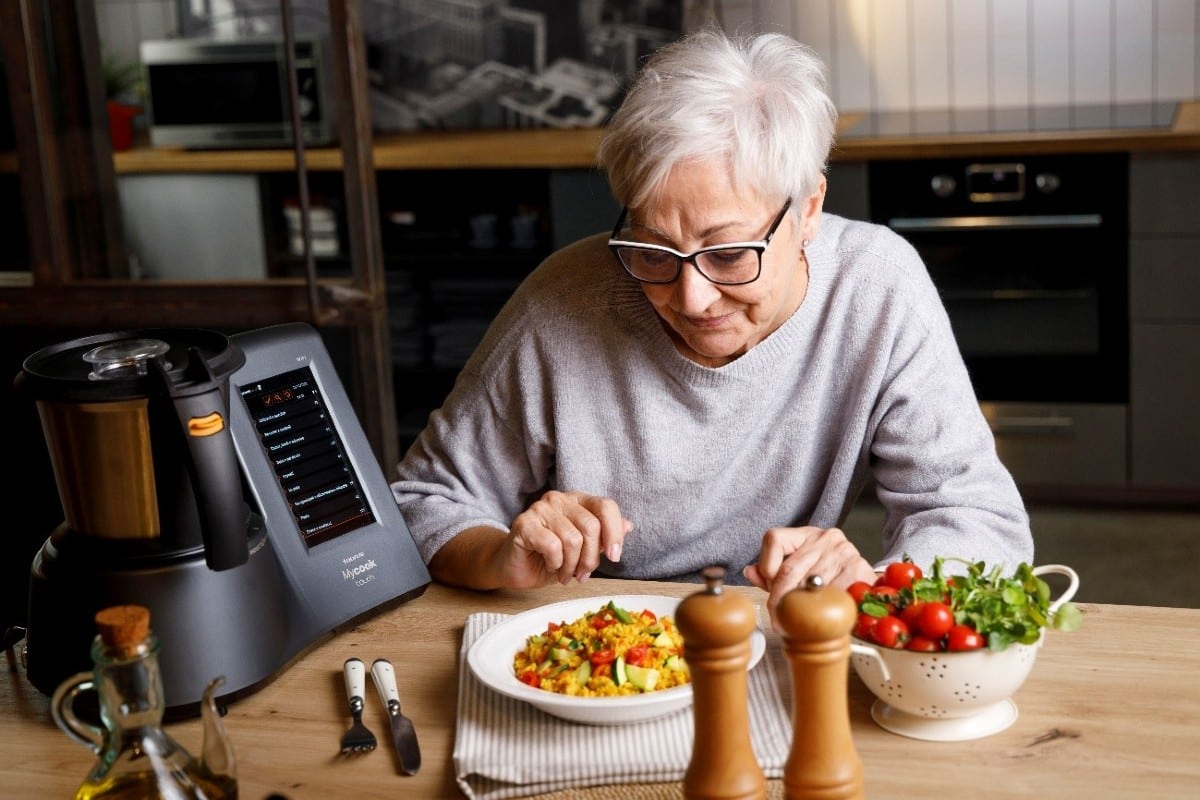 Mujer con pelo blanco junto robot de cocina Taurus