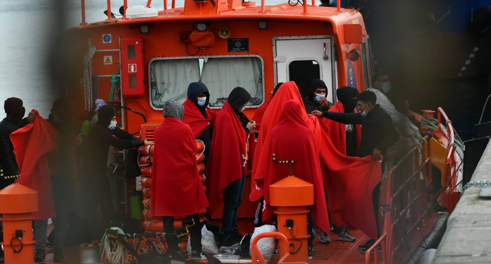 Migrantes, descendiendo de una embarcación de Salvamar en el puerto de Ceuta.