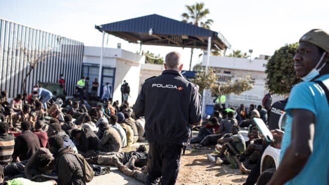 Policías nacionales, en el CETI de Melilla junto a migrantes que lograron saltar la valla el pasado 2 de marzo.