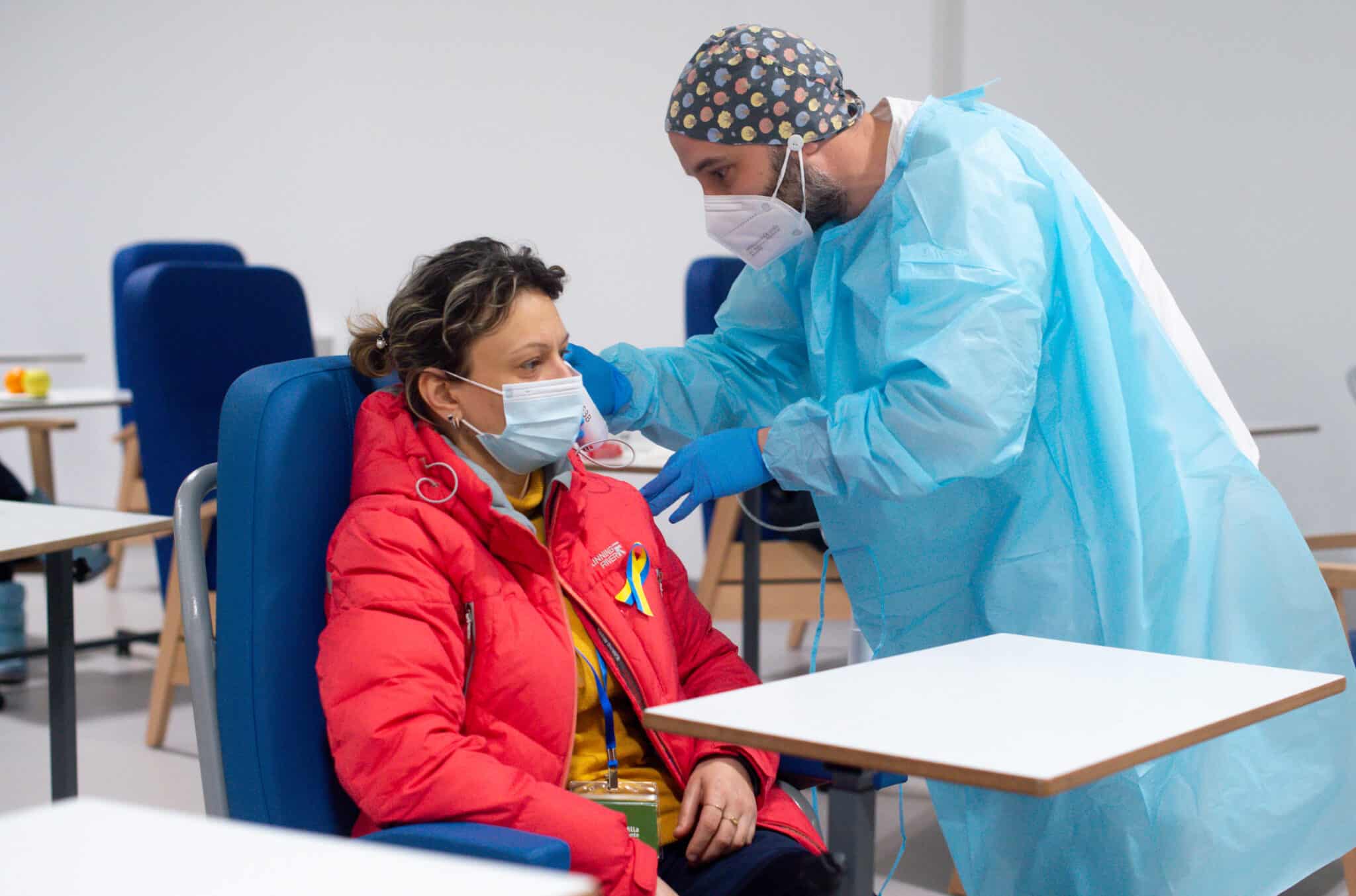 Un trabajador sanitario revisa a una persona procedente de Ucrania en las instalaciones del Hospital Enfermera Isabel Zendal, en Madrid.