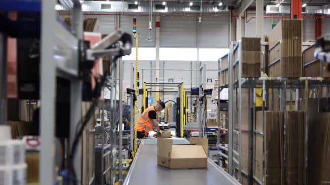 Ayuso visita las instalaciones de Amazon en Alcalá de Henares (Madrid) Un trabajador empaqueta en cajas de cartón pedidos para enviar