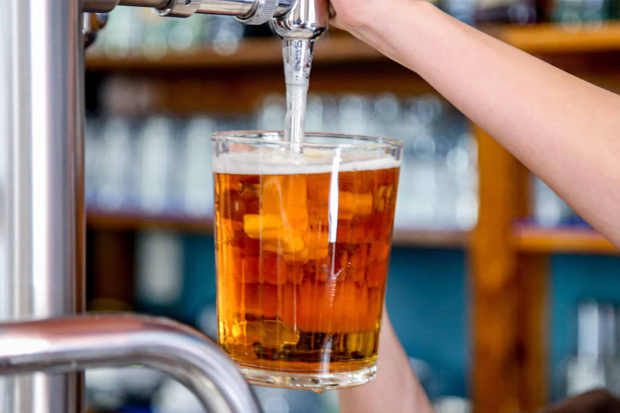 Un camarero sirve una cerveza en un bar.