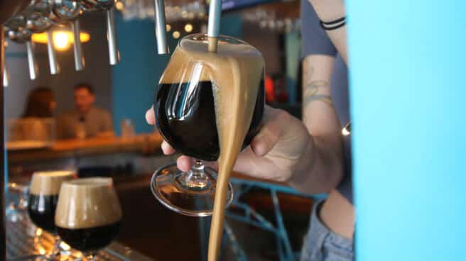 Cerveza negra artesanal siendo servida en la barra de un bar