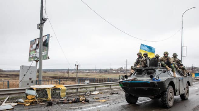 Soldados ucranianos pasan frente a un cadáver en Bucha.
