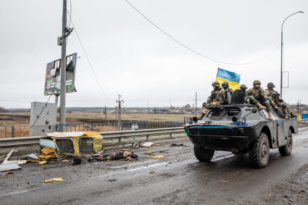 Soldados ucranianos pasan frente a un cadáver en Bucha.
