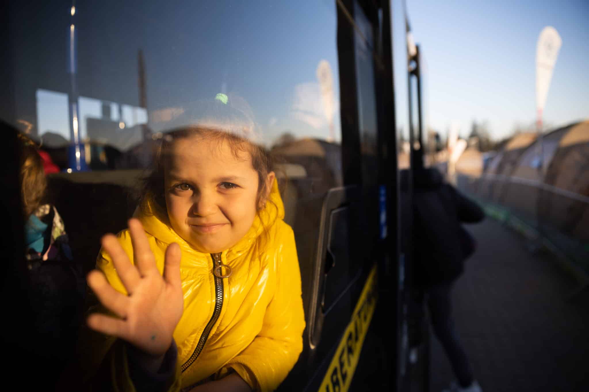Una niña ucraniana con los miembros de su familia espera en un autobús en el cruce fronterizo de Medyka