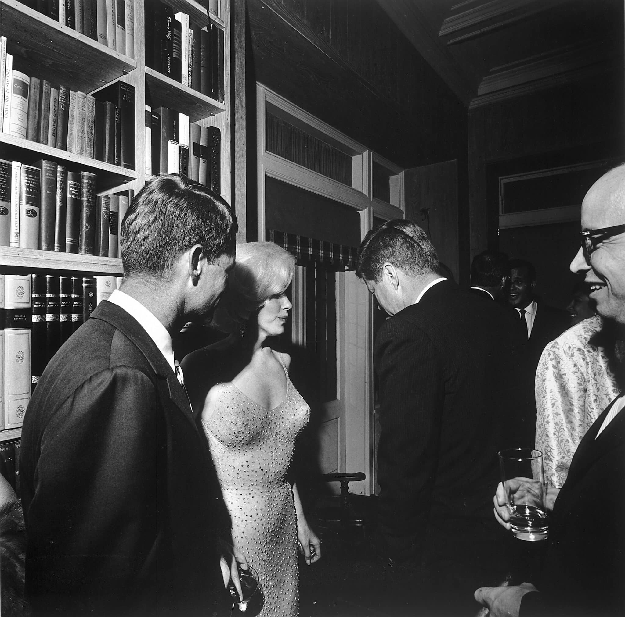 Durante una fiesta en la casa del ejecutivo de cine Arthur Krim, la actriz estadounidense Marilyn Monroe se encuentra entre Robert Kennedy (izquierda) y John F. Kennedy,