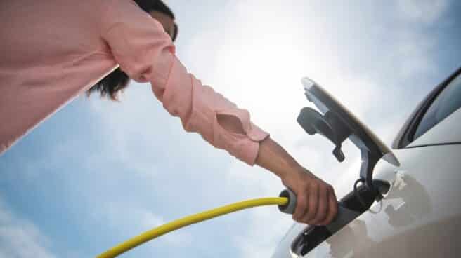 Mujer recargando un coche eléctrico