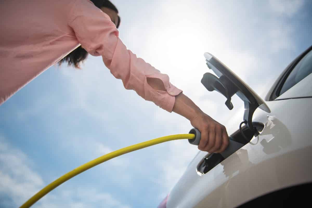 Mujer recargando un coche eléctrico