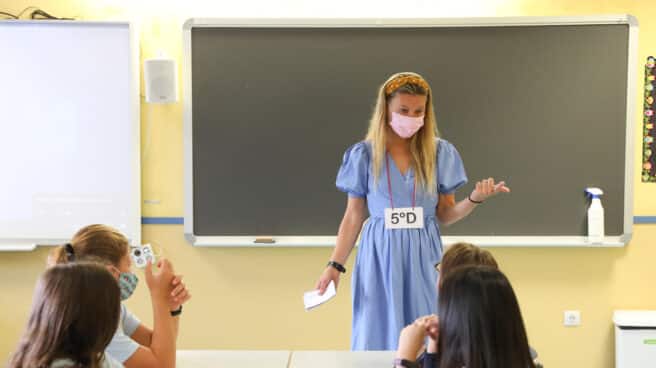 Una profesora con un grupo de niños en una de las aulas del colegio Maestro Padilla en Madrid.