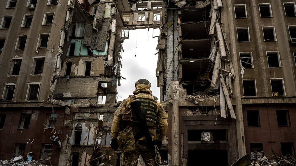 Un soldado contempla la destrucción de un edificio.