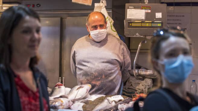 Sueño de un local en el primer día sin mascarillas en interiores Un hombre con mascarilla en un establecimiento aguarda la llegada de clientes en el mercado de Santa Catalina