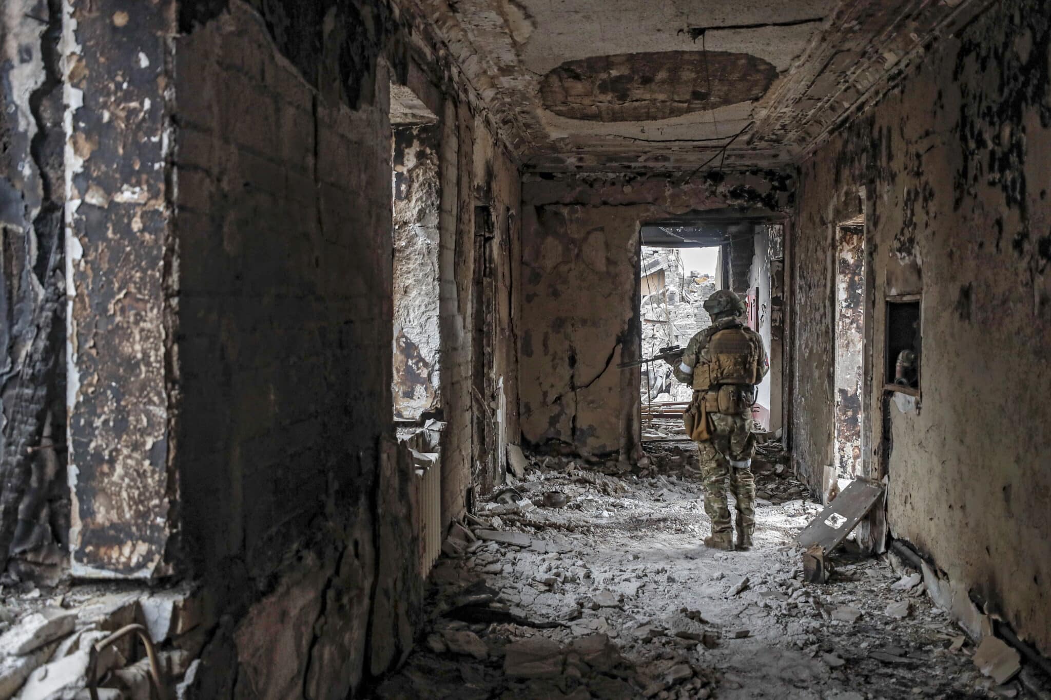 Un soldado ruso entre las ruinas del teatro de Mariúpol bombardeado por Rusia.