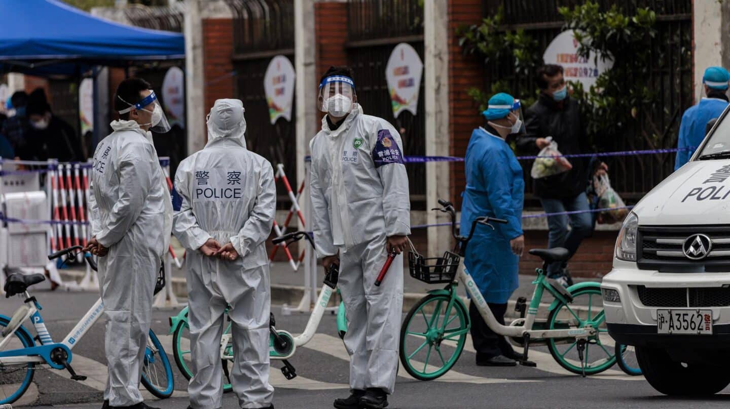 Varios policías con trajes especiales controlan las calles de Shanghai durante el confinamiento