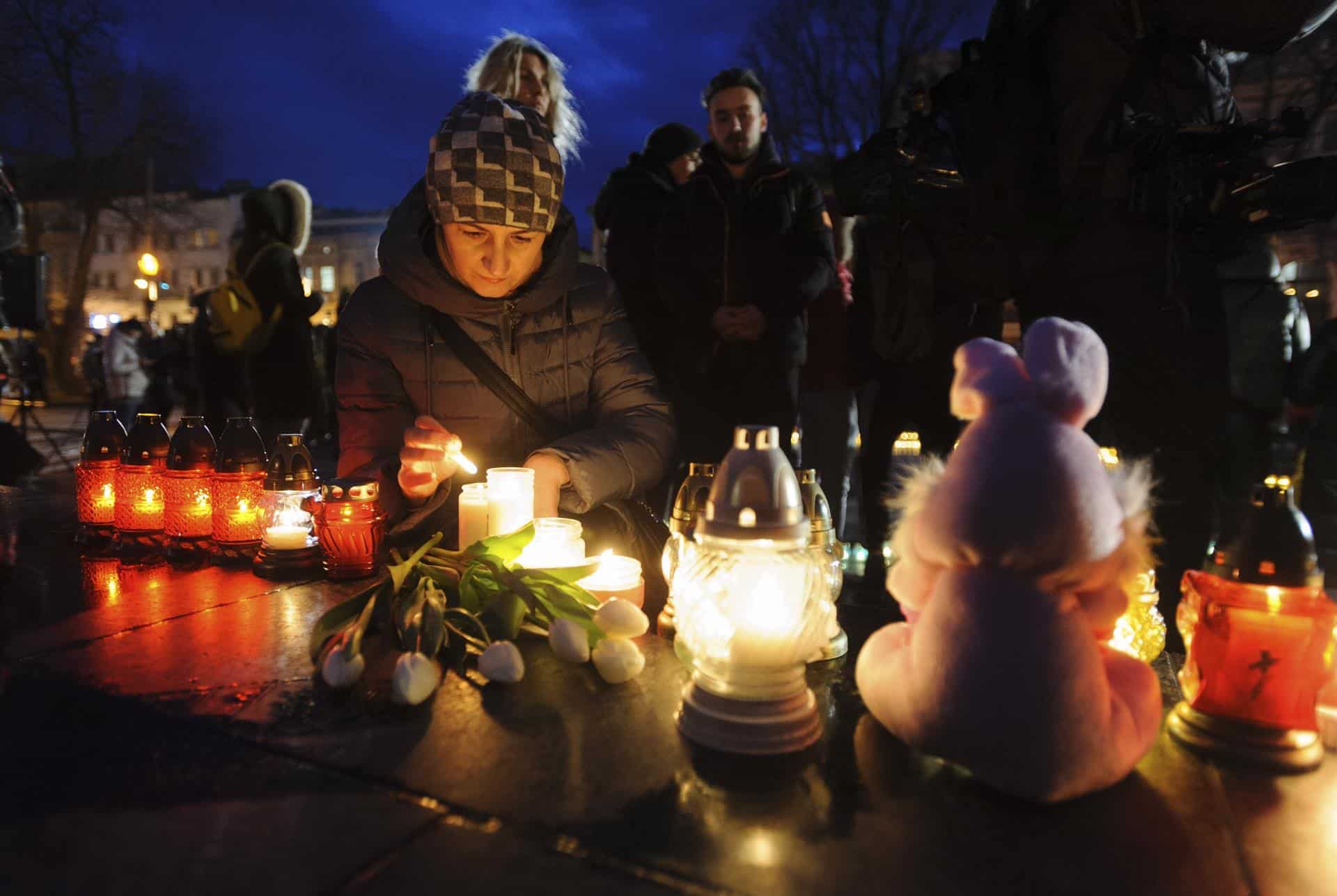 Refugiados ucranianos encendiendo unas velas en la noche