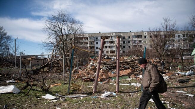 La Fiscalía de Ucrania investiga cerca de 5.800 casos de crímenes de guerra rusos Un hombre camina junto a un edificio dañado por los combates en Kiev