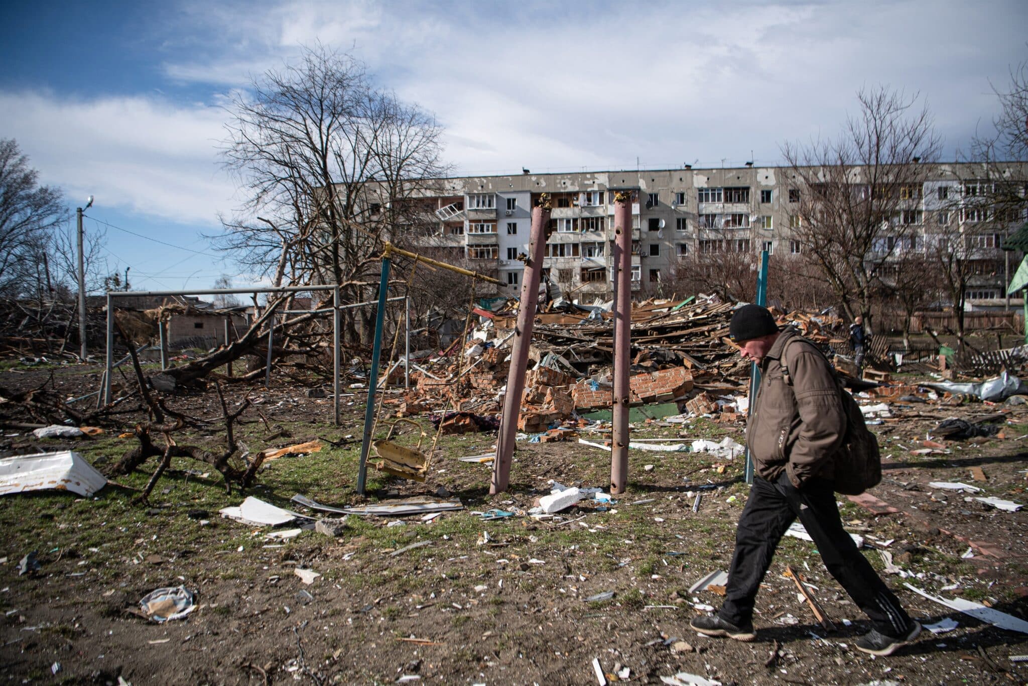 Un hombre camina junto a un edificio dañado por los combates en Kiev