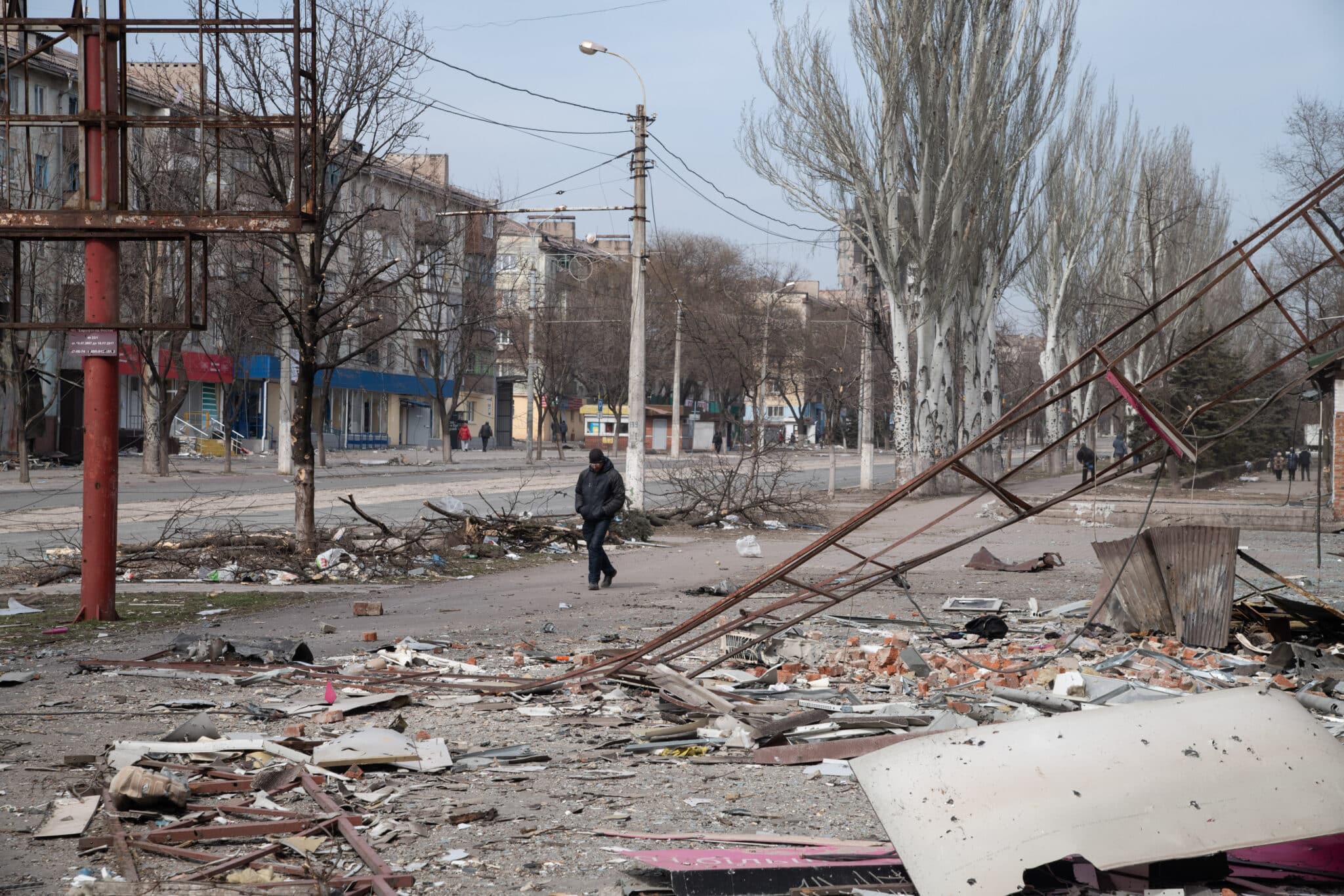 Un hombre pasea por una calle destruida por los bombardeos, en Mariupol