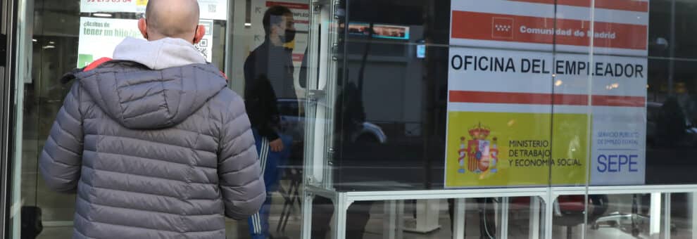 Un hombre observa la cristalera de una oficina de empleo.