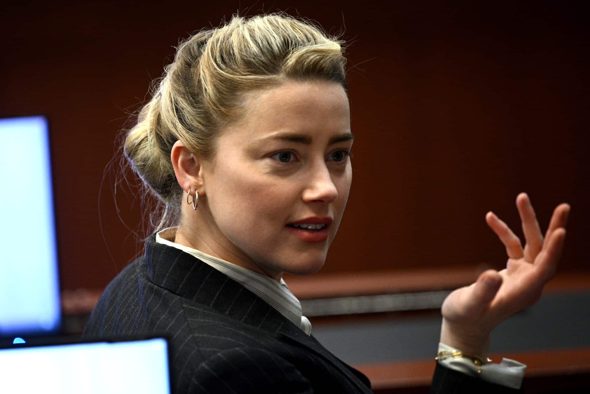 La actriz estadounidense Amber Heard hace gestos en la sala del tribunal del circuito del condado de Fairfax en Fairfax, Virginia