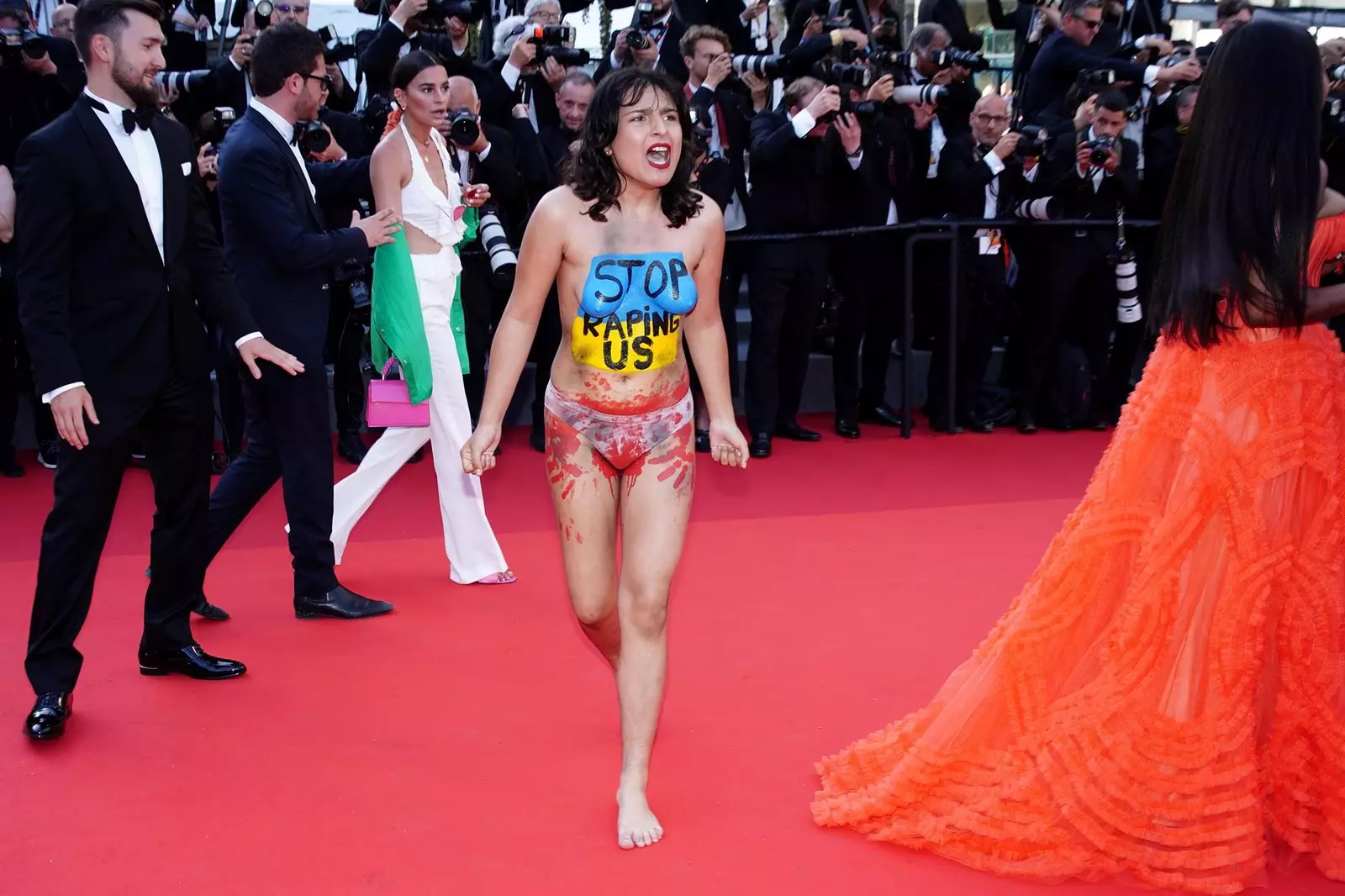 Una activista se cuela desnuda en la alfombra roja de Cannes para denunciar violaciones en Ucrania