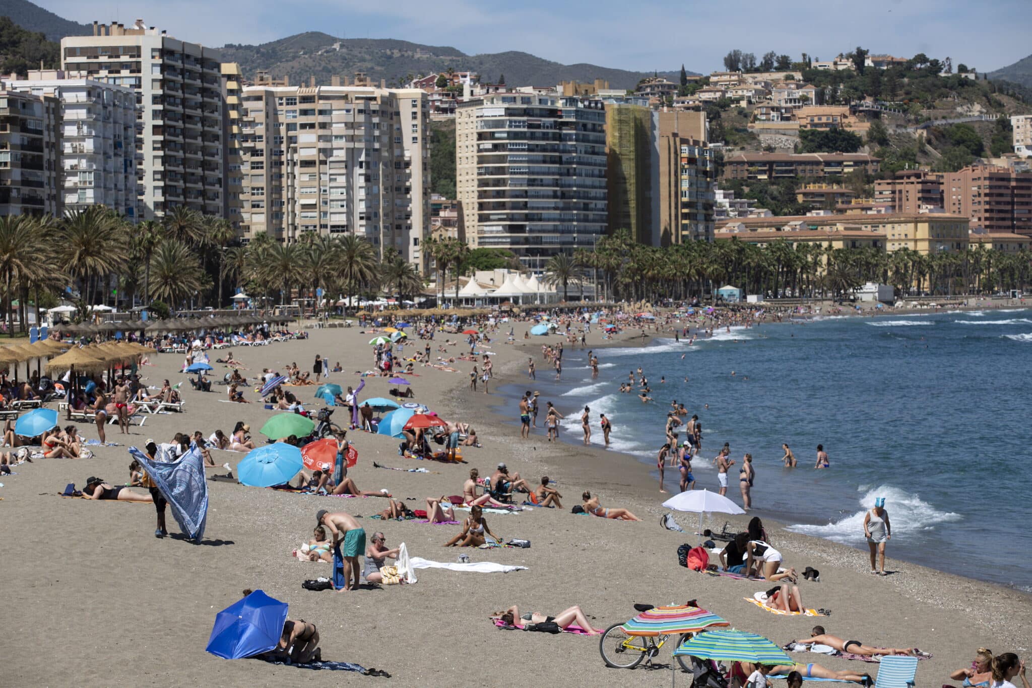 Numerosas personas disfrutan de un día de playa en La Malagueta de la capital malagueña