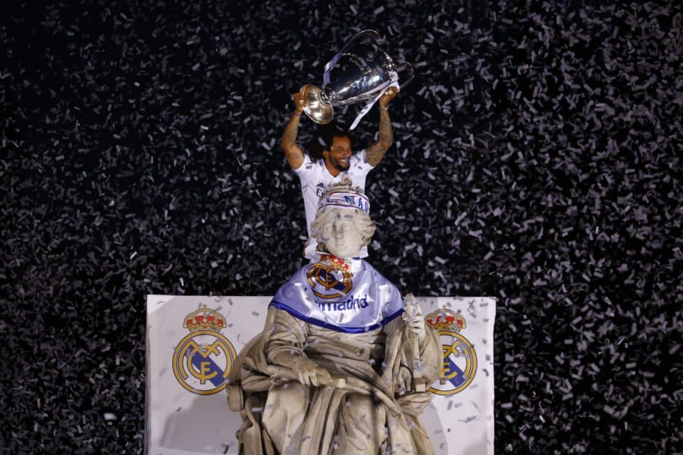 El capitan del Real Madrid Marcelo Vieira levanta la copa tras poner una bufanda a la diosa Cibeles durante la celebración con los aficionados de su victoria en la final de la