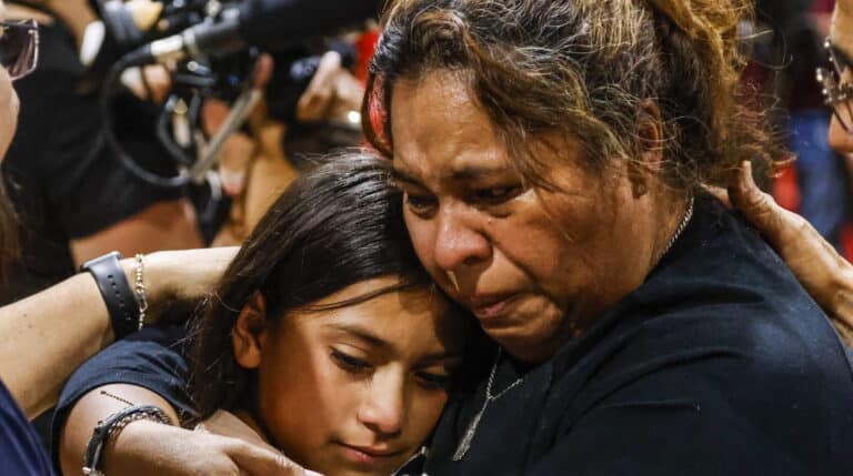 Una mujer y una niña lloran abrazadas durante la vigilia por el tiroteo en Texas