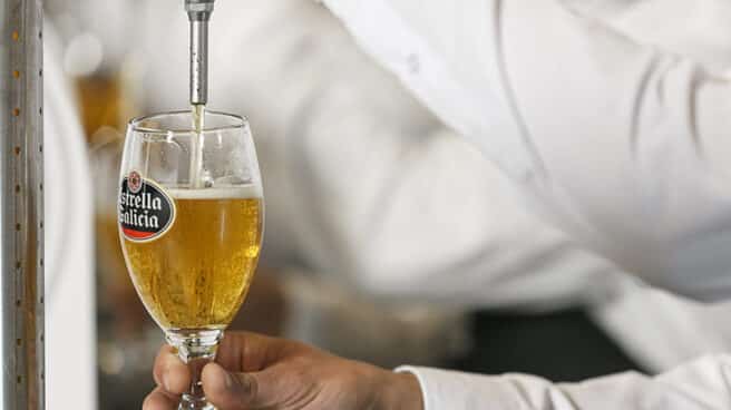 Un camarero sirve una copa de cerveza Estrella Galicia.