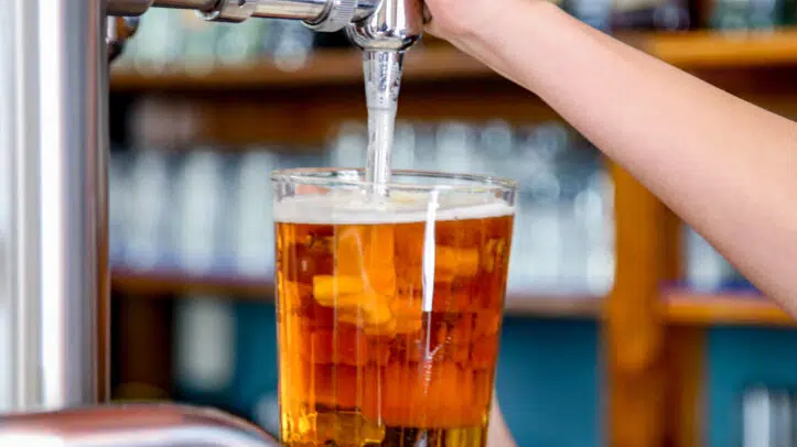 Un camarero tira una cerveza en un bar.