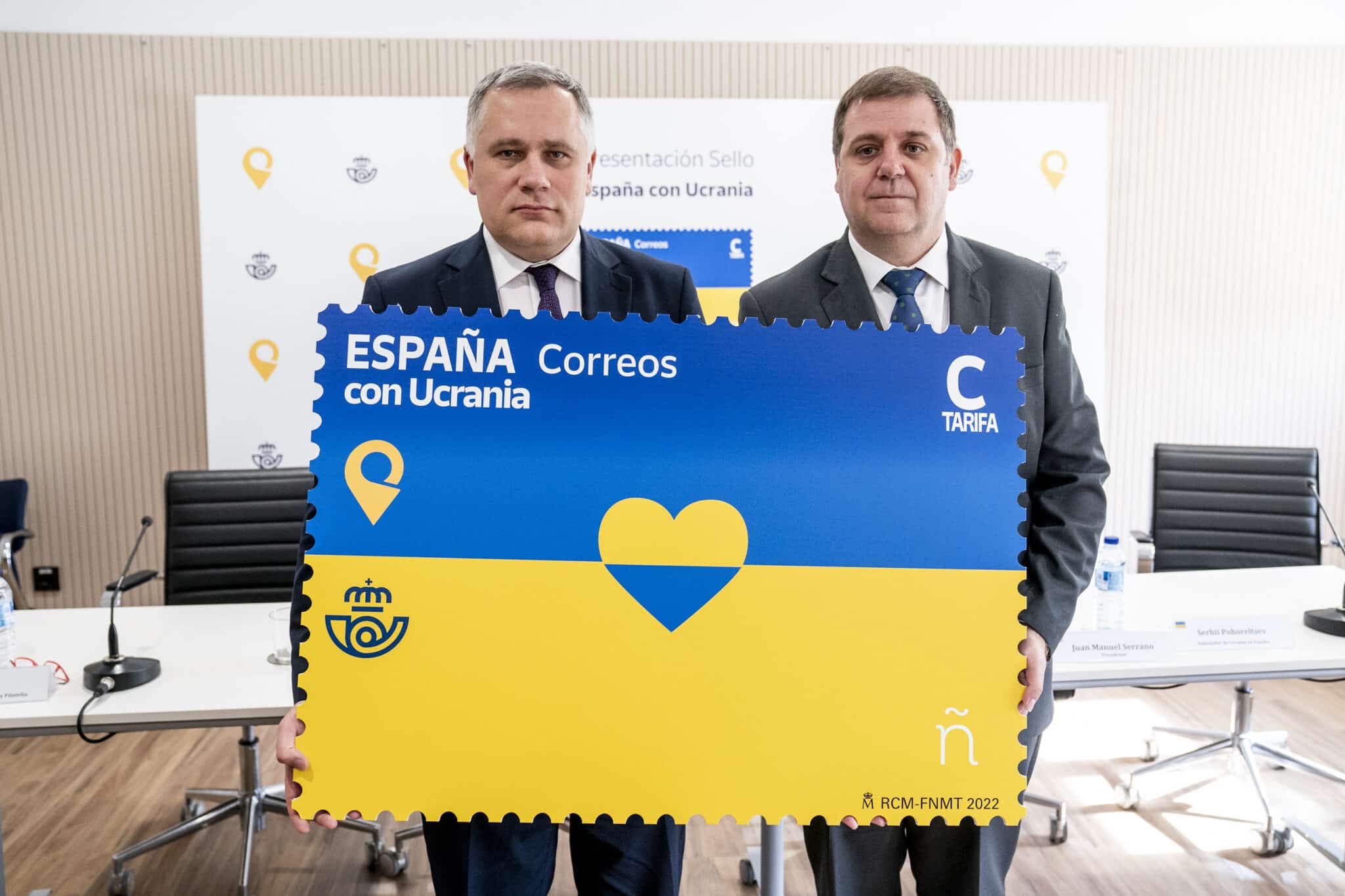 El presidente de Correos, Juan Manuel Serrano (d), y el Consejero Diplomático del Presidente de Ucrania, Igor Zhovka (i), posan con el sello dedicado a Ucrania