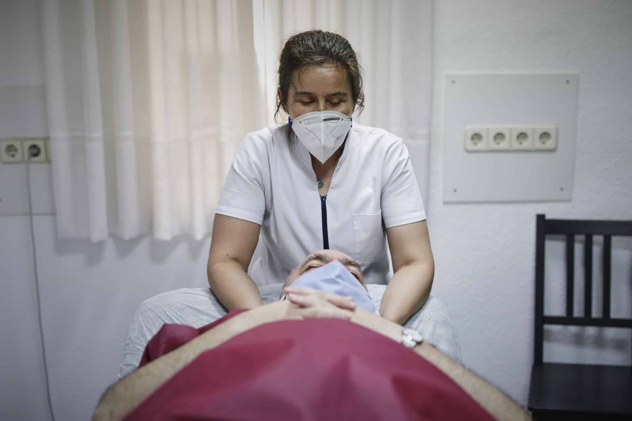 Una fisioterapeuta atiende a un paciente en una clínica.