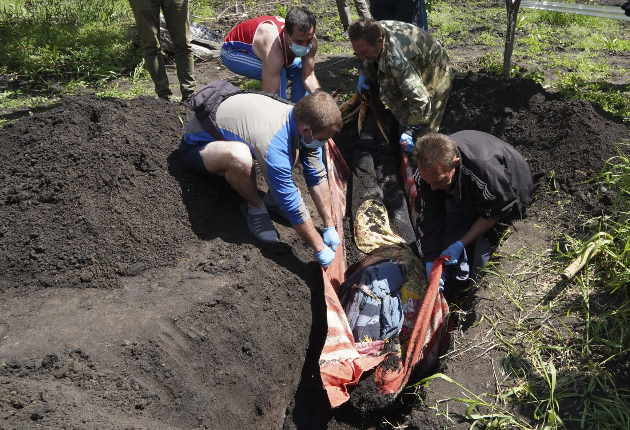 Varias personas exhuman un cuerpo en la región de Járkov