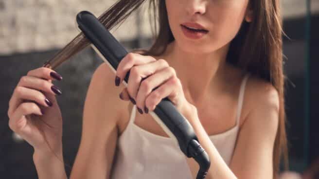 Mujer con plancha de pelo