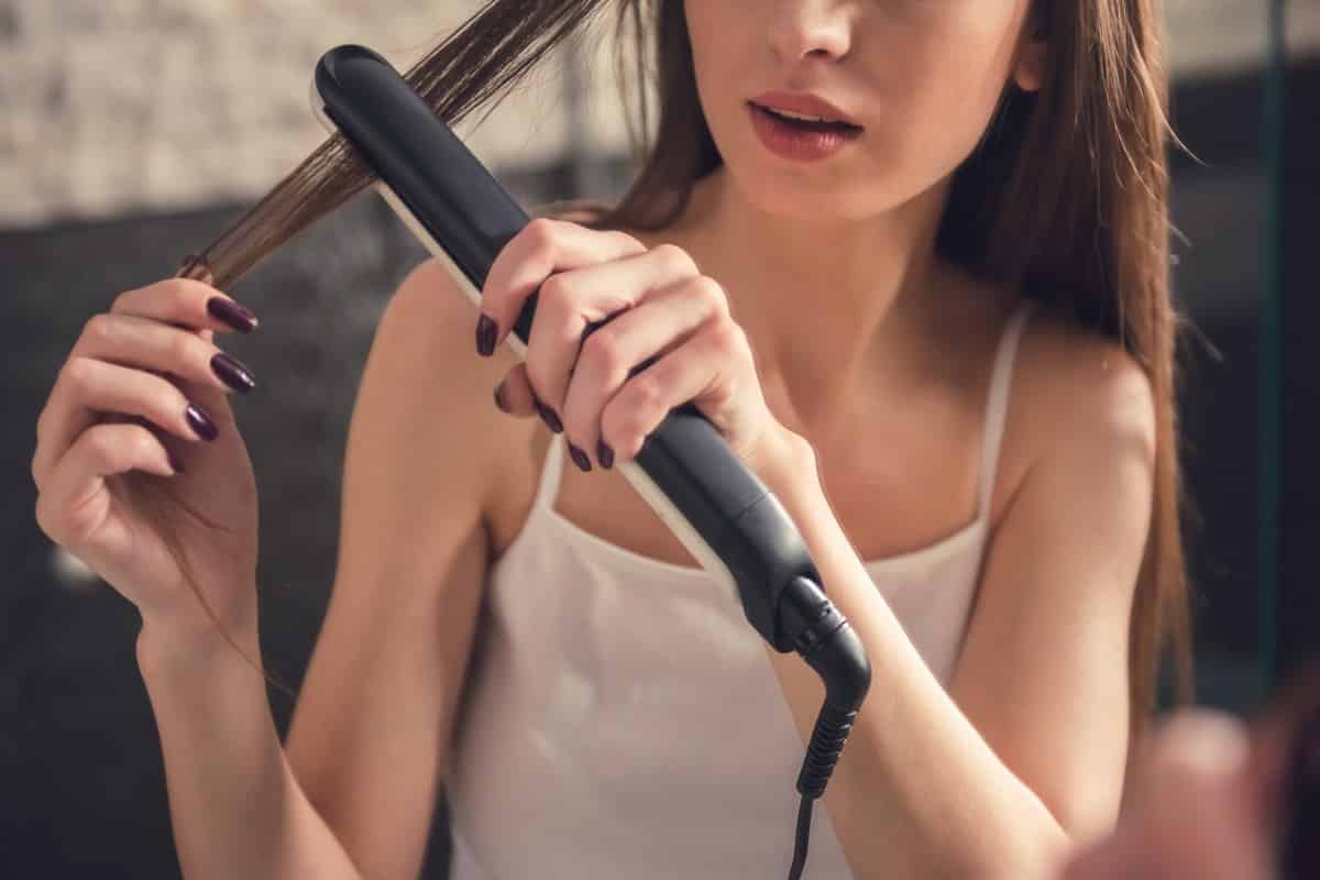 Mujer con plancha de pelo