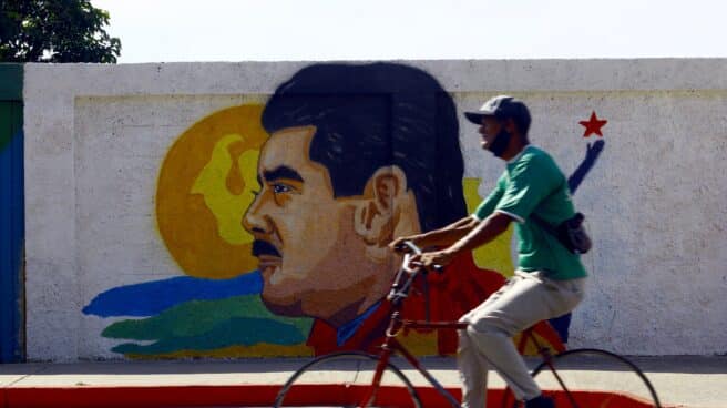 Un venezolano pasa por delante de un cartel de Maduro
