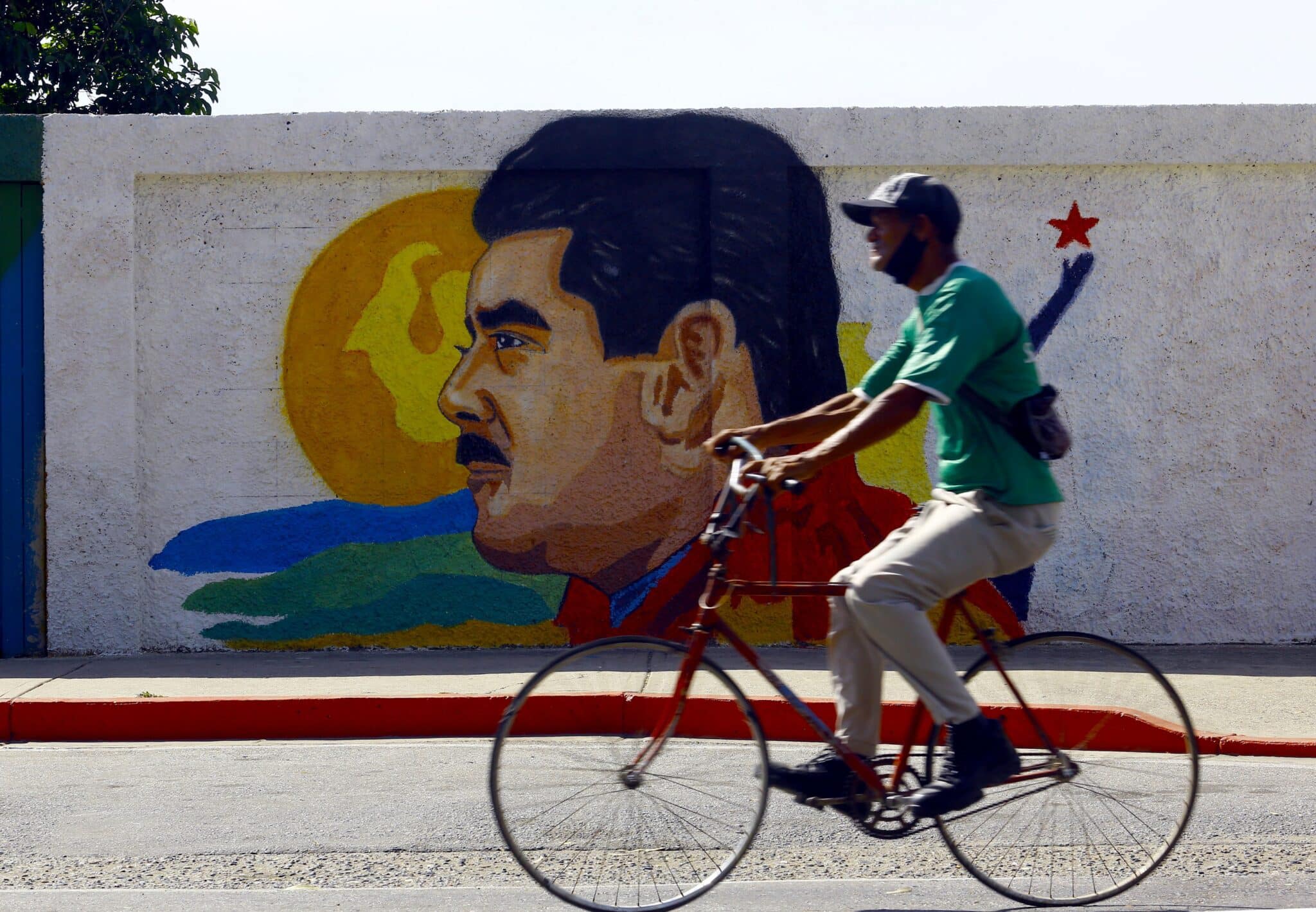 Un venezolano pasa por delante de un cartel de Maduro